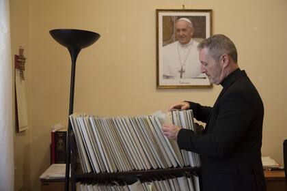 En esta foto del lunes 9 de diciembre de 2019, Monseñor John Kennedy, jefe de la sección de disciplina de la Congregación para la Doctrina de la Fe, revisa los archivos en su oficina durante una entrevista en el Vaticano