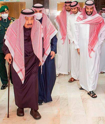 En esta foto difundida por la agencia SPA, el rey Salman de Arabia Saudí, con bastón, sale del hospital Rey Faisal acompañado por el príncipe heredero Mohammed ben Salman, derecha, en Riad, Arabia Saudí, miércoles 16 de marzo de 2022. (Saudi Press Agency via AP)