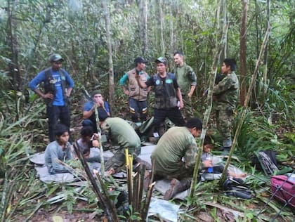 En esta foto difundida por la Oficina de Prensa de las Fuerzas Armadas de Colombia, soldados y hombres indígenas posan para la foto con los cuatro hermanos indígenas que llevaban 40 días desaparecidos, en la selva de Solano, estado de Caquetá, Colombia, el viernes 9 de junio de 2023