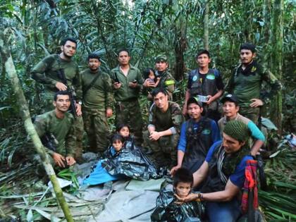 En esta foto difundida por la Oficina de Prensa de las Fuerzas Armadas de Colombia soldados e indígenas posan con los cuatro hermanos que llevaban 40 días desaparecidos en la selva de Solano, estado de Caquetá, Colombia, el viernes 9 de junio de 2023. (Oficina de Prensa de las Fuerzas Armadas de Colombia)