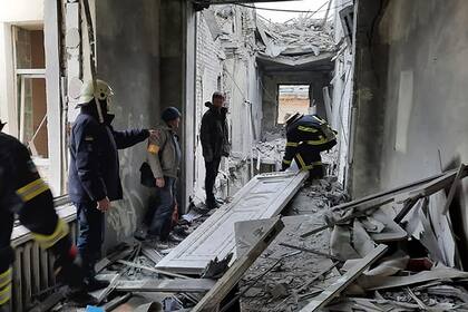 En esta foto distribuida por el Servicio de Emergencias de Ucrania, personal de emergencias inspecciona los daños en el edificio municipal de Járkiv, Ucrania, martes 1 de marzo de 2022.  (Servicio de Emergencias de Ucrania via AP)