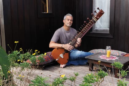 En esta foto -la misma de la apertura de esta nota en un plano más amplio-, se lo puede ver a Matías en un rincón de su casa, tocando el sitar, un instrumento tradicional de la India que tiene un sonido envolvente. Para tocarlo, hay que estar descalzo