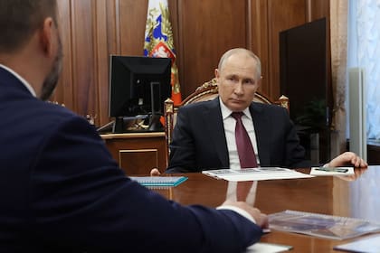 En esta fotografía de grupo distribuida por la agencia Sputnik, el presidente de Rusia, Vladímir Putin (d), observa mientras asiste a una reunión con Denis Pushilin, jefe designado por Moscú de la región ucraniana de Donetsk -controlada por las fuerzas rusas-, en Moscú, el 24 de agosto de 2023