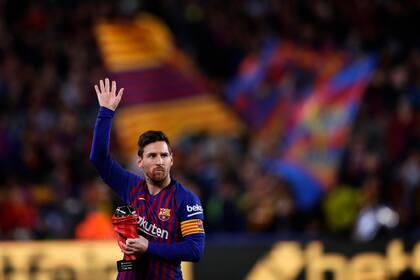 En esta fotografía del sábado 6 de abril de 2019, el delantero del Barcelona Lionel Messi saluda a la multitud mientras sostiene el trofeo al mejor jugador de La Liga española antes de un partido de fútbol entre el FC Barcelona y el Atlético de Madrid en el estadio Camp Nou de Barcelon, España