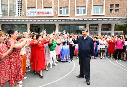 En esta fotografía difundida por la agencia de noticias china Xinhua, el presidente chino Xi Jinping, centro, visita la comunidad de Guyuanxiang, en el distrito Tianshan en Urumqi, en la región autónoma china uigur de China, el miércoles 13 de julio de 2022. (Li Xueren/Xinhua vía AP)