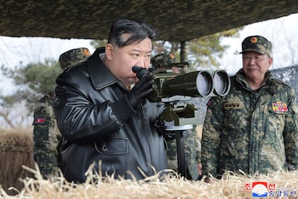 En esta fotografía proporcionada por el gobierno norcoreano, el gobernante Kim Jong Un, al centro, supervisa ejercicios de disparos de artillería el 7 de marzo de 2024, en Corea del Norte