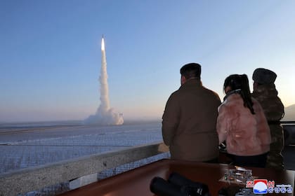 En esta fotografía sin fecha proporcionada el lunes 18 de diciembre de 2023 por el gobierno norcoreano, Kim Jong Un, su hija y un funcionario observan lo que dice es un misil balístico intercontinental 