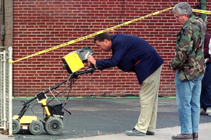 En esta imagen de archivo de 1998, investigadores buscan con un radar posibles víctimas del asesino serial John Wayne Gacy, quien fue ejecutado en 1994
