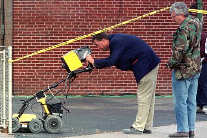 En esta imagen de archivo de 1998, investigadores buscan con un radar posibles víctimas del asesino serial John Wayne Gacy, quien fue ejecutado en 1994