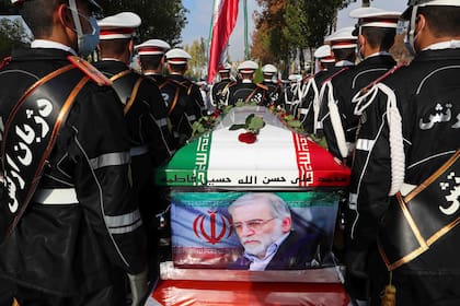 En esta imagen de archivo, distribuida por la web oficial del Ministerio de Defensa de Irán, soldados hacen guardia junto al ataúd, envuelto en una bandera, de Mohsen Fakhrizadeh, un científico asesinado, durante su cortejo fúnebre, el 30 de noviembre de 2020