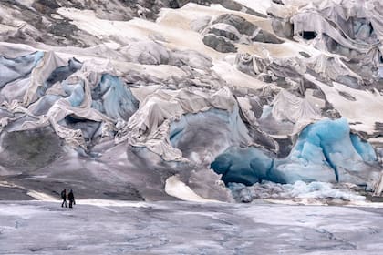 En esta imagen de archivo, dos miembros de un equipo del Instituto Federal de Tecnología de Suiza, llegan al glaciar Rhone, cerca de Goms, Suiza