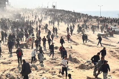 En esta imagen de archivo, palestinos esperan ayuda humanitaria en una playa en la Ciudad de Gaza, en la Franja de Gaza (Archivo)