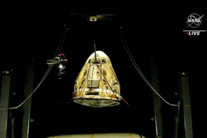 En esta imagen de un video distribuido por NASA, alzan la cápsula espacial SpaceX Dragon de aguas del Golfo de México, viernes 6 de mayo de 2022. Los astronautas Raja Chari, Tom Marshburn y Kayla Barron de la NASA y Matthias Maurer de la Agencia Espacial Europea regresaron de la Estación Espacial Internacional.
