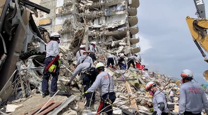 En esta imagen, distribuida por el departamento de bomberos de Miami-Dade, rescatistas buscan a sobrevivientes entre los escombros del edificio Champlain Towers South, en Surfside, Florida, el 25 de junio de 2021. (Departamento de bomberos de Miami-Dade vía AP)