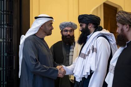 En esta imagen, distribuida por la agencia noticiosa estatal WAM, el líder emiratí jeque Mohammed bin Zayed Al Nahyan, que gobierna en Abu Dabi (izquierda), estrecha la mano del funcionario talibán Sirajuddin Haqqani en el palacio Qasr Al Shati en Abu Dabi, Emiratos Árabes Unidos, el 4 de junio de 2024. (WAM vía AP)