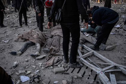 En esta imagen obtenida de la agencia de noticias iraní ISNA el 3 de marzo de 2026, varios cuerpos yacen en el suelo tras un ataque contra un edificio en la plaza Enghelab, en Teherán