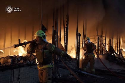 En esta imagen proporcionada por el Servicio Ucraniano de Emergencias, el jueves 7 de noviembre de 2024, rescatistas apagan un incendio en un edificio tras un ataque de dron ruso en Kiev, Ucrania. (Servicio Ucraniano de Emergencias via AP)