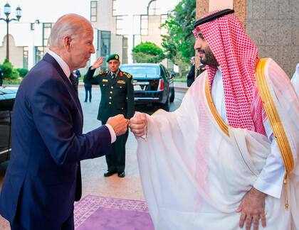 En esta imagen publicada por el Palacio Real saudí, el príncipe heredero saudí Mohammed bin Salman saluda al presidente estadounidense Joe Biden chocando los puños a su llegada en Yeda, Arabia Saudita, el viernes 15 de julio de 2022. 