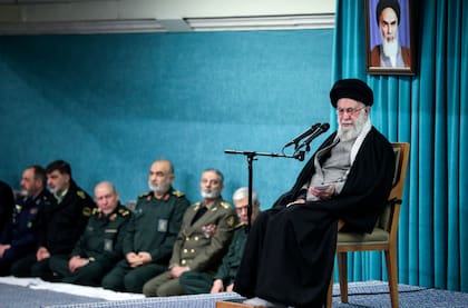 En esta imagen publicada por el sitio oficial de la oficina del líder supremo de Irán, el ayatolá Alí Jamenei, líder supremo del país, habla bajo un retrato del líder revolucionario el ayatolá Jomeini, mientras mandos militares escuchan, al fondo, en una reunión de autoridades en Teherán, Irán, el sábado 8 de marzo de 2025. (Oficina del líder supremo de Irán via AP)