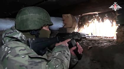 En esta imagen, tomada de un video distribuido por el Ministerio de Defensa de Rusia el 24 de octubre de 2024, un soldado ruso apunta desde un búnker en la región fronteriza rusa de Kursk