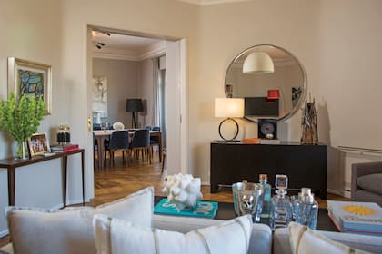 En esta vista, desde el living hacia el comedor, una escultura de Mariana Villafañe delante del espejo circular. Sobre la mesa de arrime de la izquierda, un cuadro de Carlos Paez Vilaró.