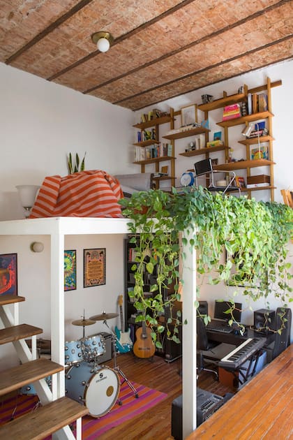 En este ambiente, igual que en el dormitorio principal contiguo, la pino tea se reparó, pulió e hidrolaqueó. Aprovechando la estructura de un entrepiso existente, se generó un espacio de escritorio. Biblioteca de petiribí (La Base Studio) y alfombra rayada en pura lana (Seara).