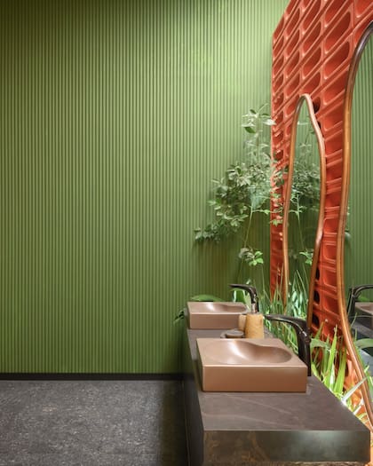 En este baño de doble bacha, el revestimiento de pared Snail blanco pintable se combina con un zócalo Shadow negro mate.