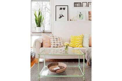 En este living, una antigua mesa con estructura de hierro y tapa de vidrio se ve renovada a través del color verde menta, tan delicado y fresco para un ambiente actual