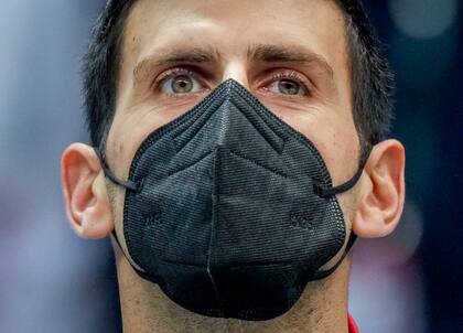 En foto del 26 de noviembre del 2021, el serbio Novak Djokovic usa mascarilla durante la ceremonia de los himnos nacionales, antes de un partido de la Copa Davis entre su país y Austria, en Innsbruck