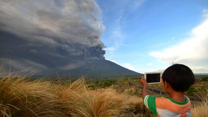 Un ni?o con una tablet toma una fotografía del volcán