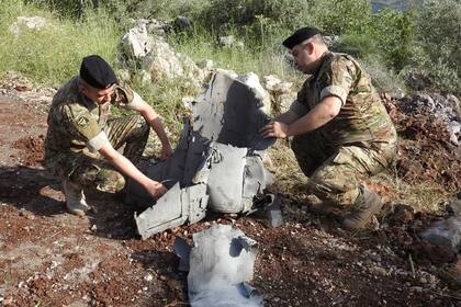 Soldados inspeccionan restos de misiles que cayeron durante el bombardeo