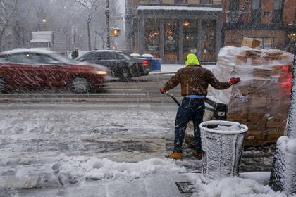 A pesar de la nieve y el frío, un hombre descarga mercadería en plena tormenta