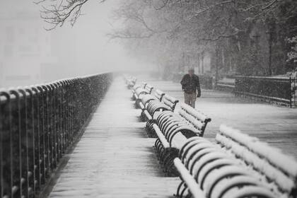 Un hombre camina por el paseo marítimo de Brooklyn que se encuentra cubierto de nieve