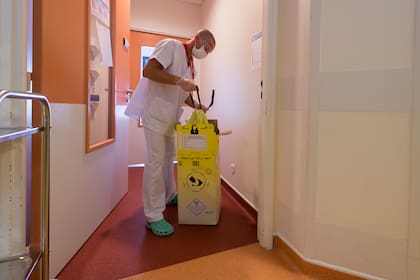 En Francia un trabajador sanitario desecha residuos infectados por el coronavirus