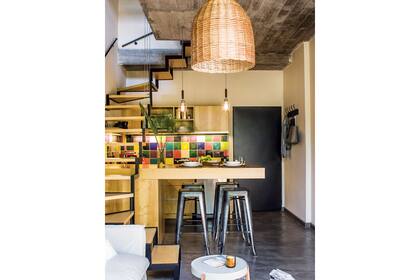 En la barra, banquetas ‘Tolix’ ($1.000, Bruta Deco), lámparas ‘Flor’ ($890, Estación Ortiz) y vajilla ‘Flat’ ($1.849) sobre individuales de ratán ($380 c/u, Petite Margot). Piso de microcemento gris (Urbánico)