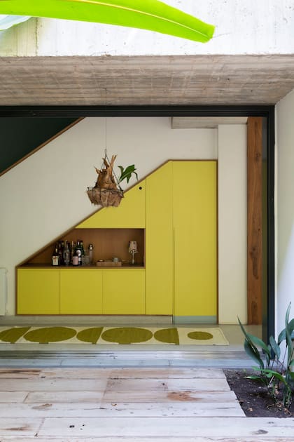 En la casa A, bar a la vista y los papeles guardados tras puertas laqueadas en amarillo.