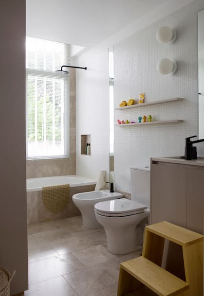 En la casa de Cielo Pipkin el baño de los chicos tiene estantes, piso y mesada en mármol ‘Moon Beige’ (De Stefano). Vanitory en melamina ‘Gris Arcilla’ (Egger). Escalera ‘Kellu’ (Tortuga). Artefactos de iluminación ‘Robin 1’ (Dimm)