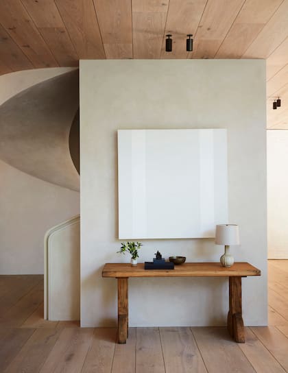 En la casa que vemos acá y en las dos imágenes que siguen, pisos y techos de madera natural se combinan con una paleta neutra que va de los textiles a las obras de arte.