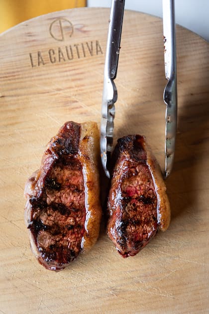 En La Cautiva los cortes salen de la parrilla al plato de madera.