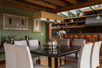 En la cocina, se destaca la campana en negro. El bar se hizo con maderas rústicas que sobraron de la obra, y el mobiliario, a medida en lenga que se trató para que se viera el aserrado pero fuera suave al tacto.