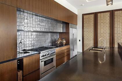 En la cocina se destaca la isla de mármol oscuro