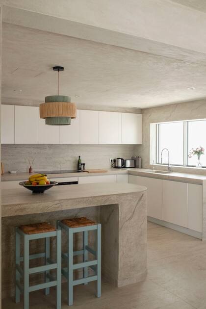 En la cocina también eligieron piso de porcelanato (Flaviker Ceramiche) y revestimientos de pared y techo, mesadas e isla en estuco terminado a mano.
