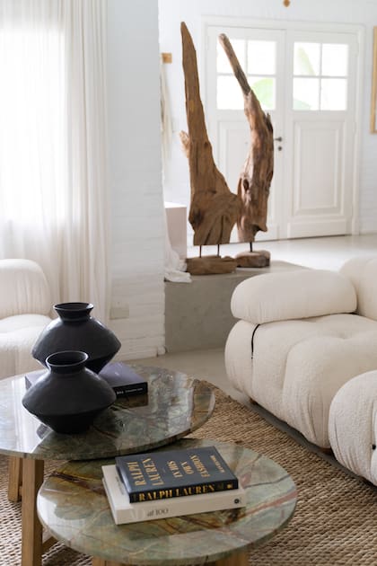 En la entrada, tótem de madera y cerámicas negras sobre las mesas de centro, y alfombra de yute, todo de Gloria Atelier Deco, tienda que la asesoró con el interiorismo