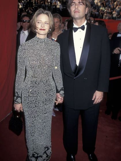 En la foto, Jodie Foster y Randy Stone llegan a los Premios Oscar de 1995. Esa noche Foster, ataviada en su vestido ajustado, con cuello cisne y aplicaciones bordadas que creaban patrones geométricos, se alzó con un premio Oscar por su interpretación en Una mujer llamada Nell