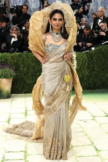 En la gala del MET, Isha brilló con un sari en tejido
de oro puro (con la firma de Gaurav Gupta) y un
deslumbrante conjunto de alta joyería. El soutien
tenía cosidos más de 1800 quilates de diamantes,
esmeraldas, piedras polki y kundan, procedentes de
la colección privada de su madre, Nita Ambani, de
valor incalculable. . Completó el outfit con una cartera
“mango”, una escultura de Subodh Gupta, cuyo
valor es de 100 mil dólares.