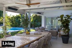 En la galería de @aloha_paisajismo, techo con caños rectangulares que arman una grilla. La mesa en madera maciza, diseño de Estudio Flombaum, se acompañó con unas sillas y un ventilador de diseño importados (similares, en Ventto)