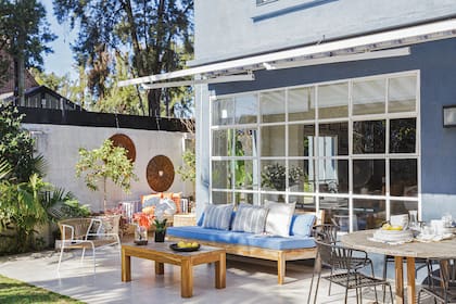 En la galería se eligieron unas sillas de modelo metálico con tejido de cintas con protección UV (Salazar Casa), un camastro con almohadones y una mesa de lapacho.