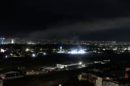 En la imagen, humo en el aeropuerto de La Carlota tras varias explosiones y aviones volando a baja altura en Caracas, Venezuela, el 3 de enero de 2026. (AP Foto/Matías Delacroix)