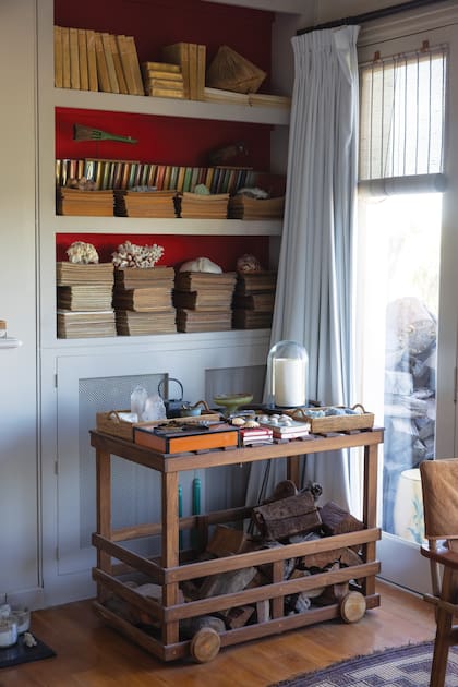 En la mesa-carro que tienen en la habitación principal, velas, recuerdos preciados de viajes y troncos para prender el fuego en la chimenea