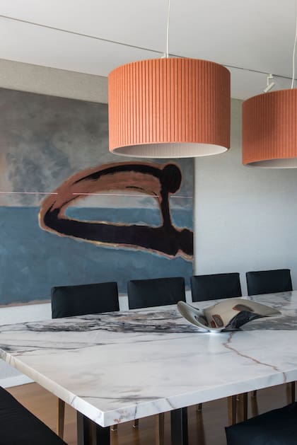 En la obra de Rómulo Macciò convergen muchos tonos presentes en el comedor entelado. Sobre la mesa con tapa de Neolith (Bull Buenos Aires), centro de la marca danesa Georg Jensen.